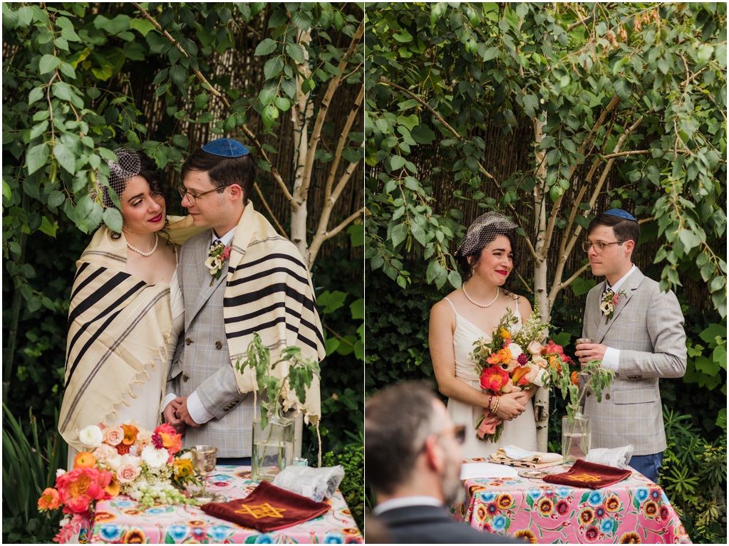 The couple stands at the altar with a prayer shawl around their shoulders