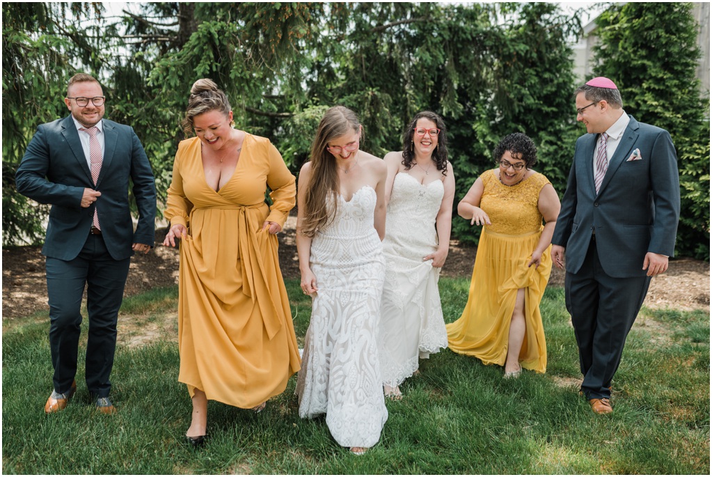 A photo of the brides laughing with their wedding parties