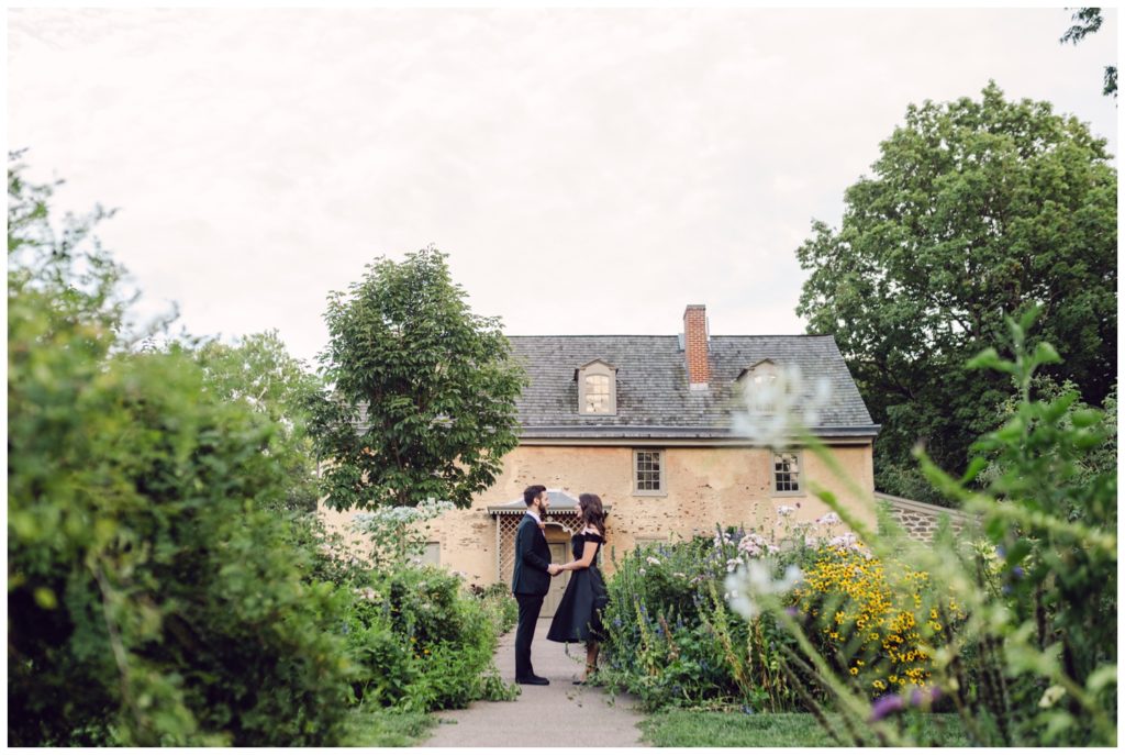 The couple stands outside a stone building at the Bartram's garden wedding