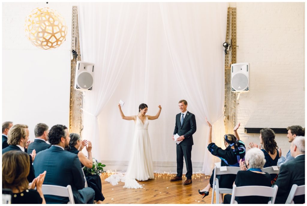 Bride lifts her arms during Power Plant Productions wedding