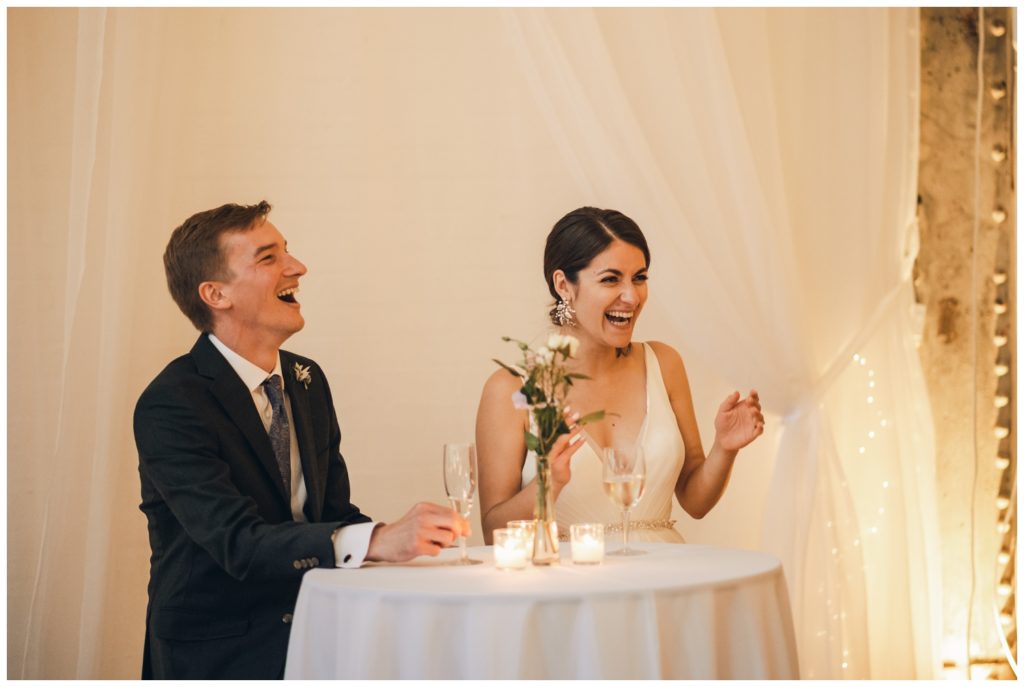 The couple laughs during toasts