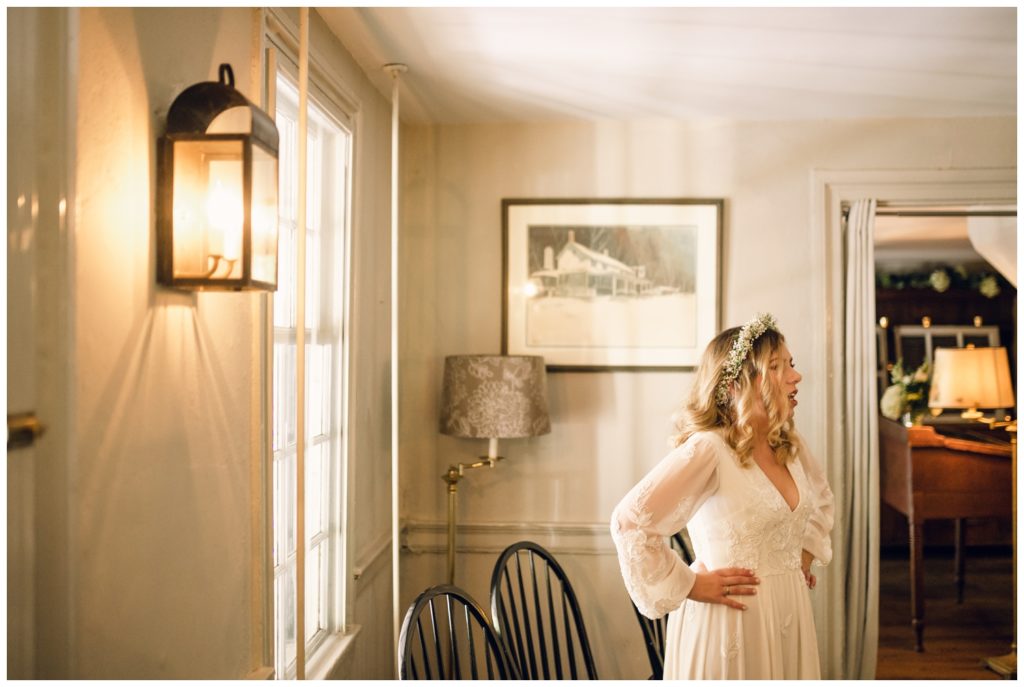 The bride stands by a window at the Valley Green Inn wedding