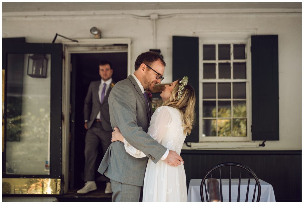 The couple kisses on the porch of the Valley Green Inn wedding