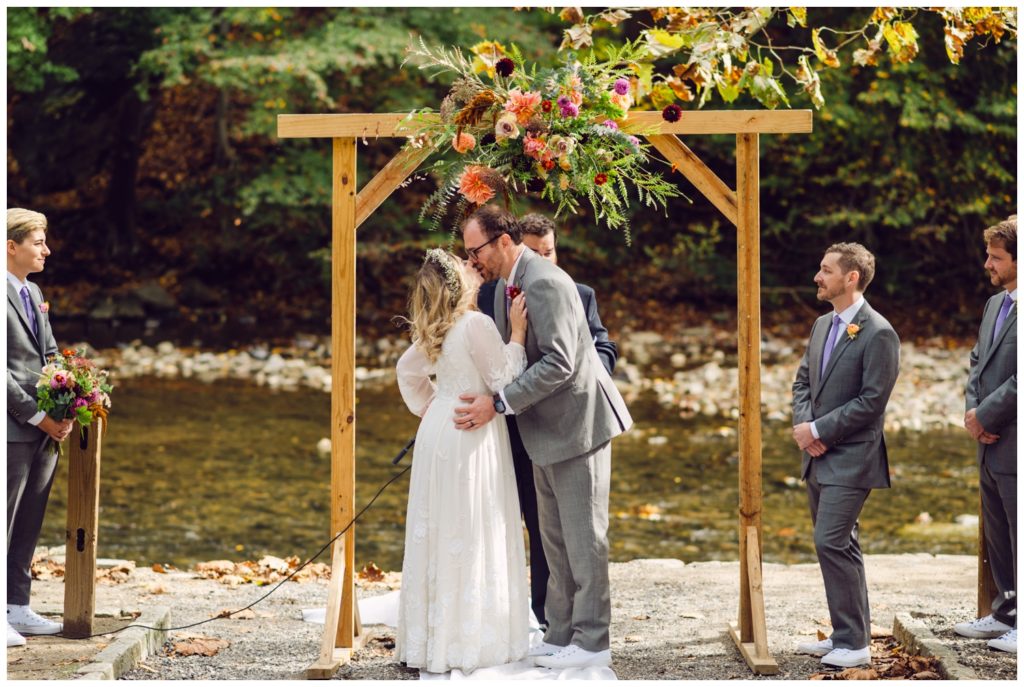 The couple kisses under the arbor at the Valley Green Inn wedding