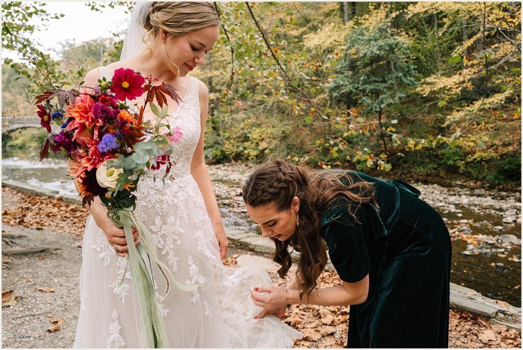 A woman bustles a bride's dress.
