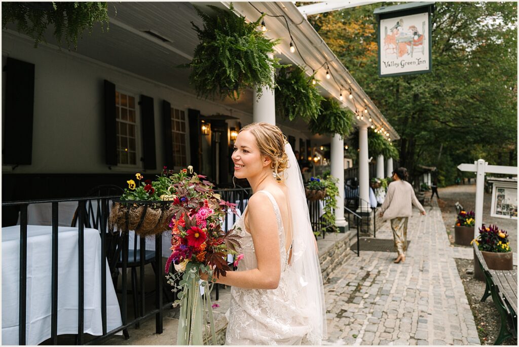 A bride walks towards the porch of the Valley Green Inn.