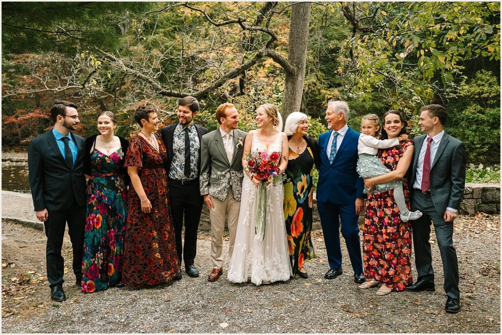 A bride and groom pose with family members.