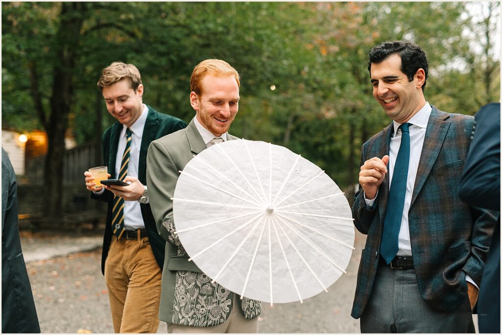 A groom opens a parasol.