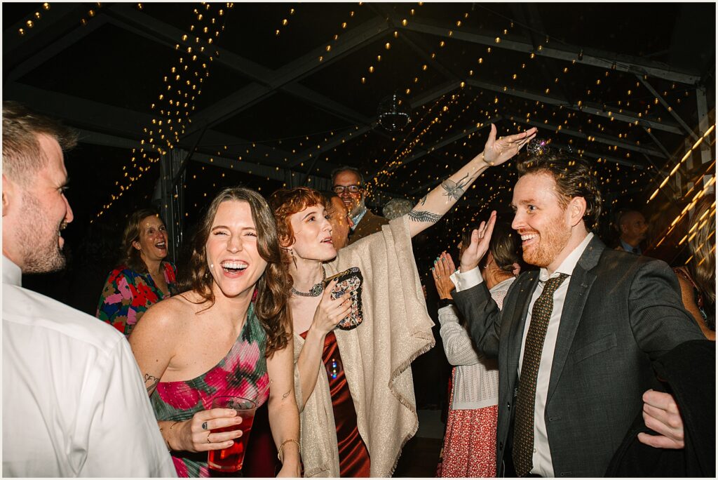 Wedding guests laugh and dance.