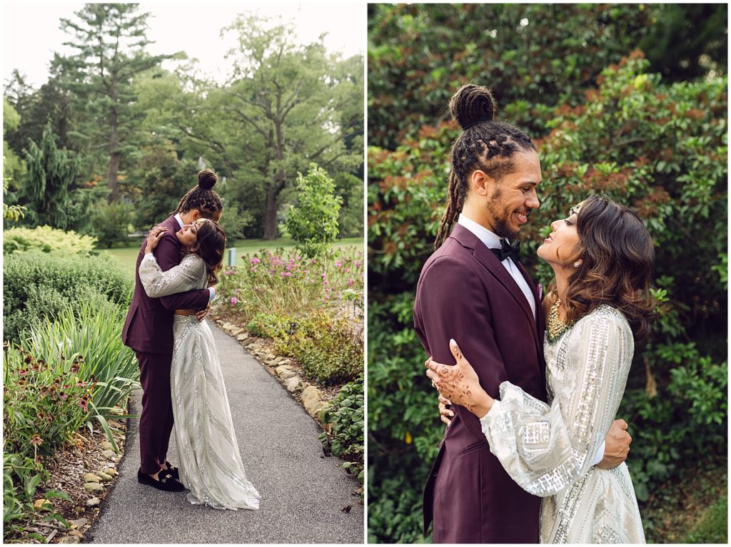 A couple embraces on a garden path before their Tyler Arboretum wedding.
