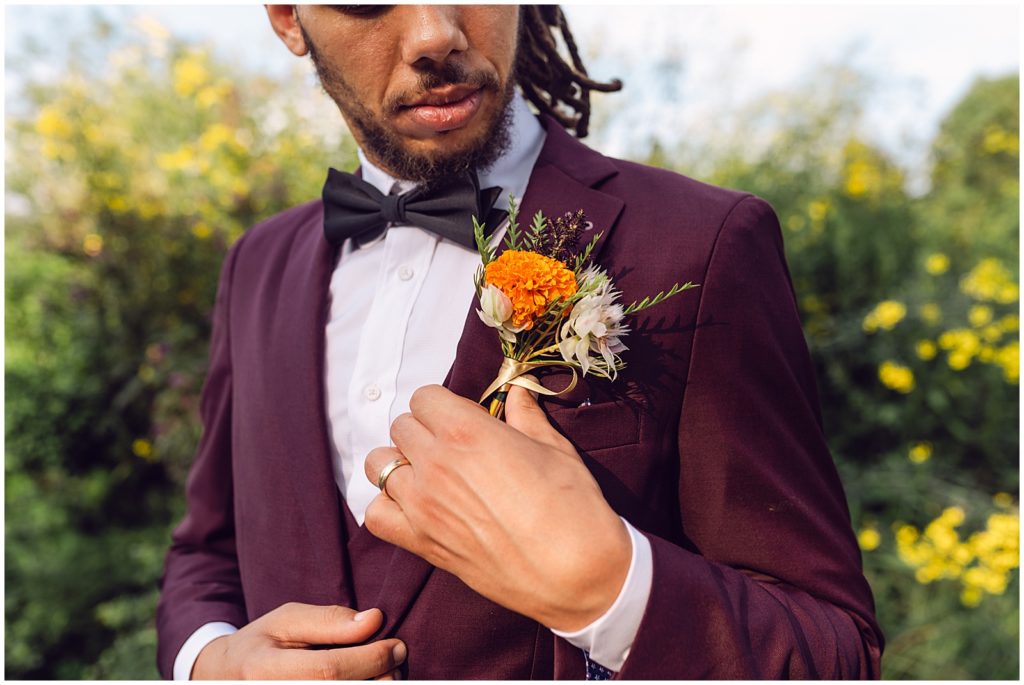 The groom wears a marigold on his lapel.