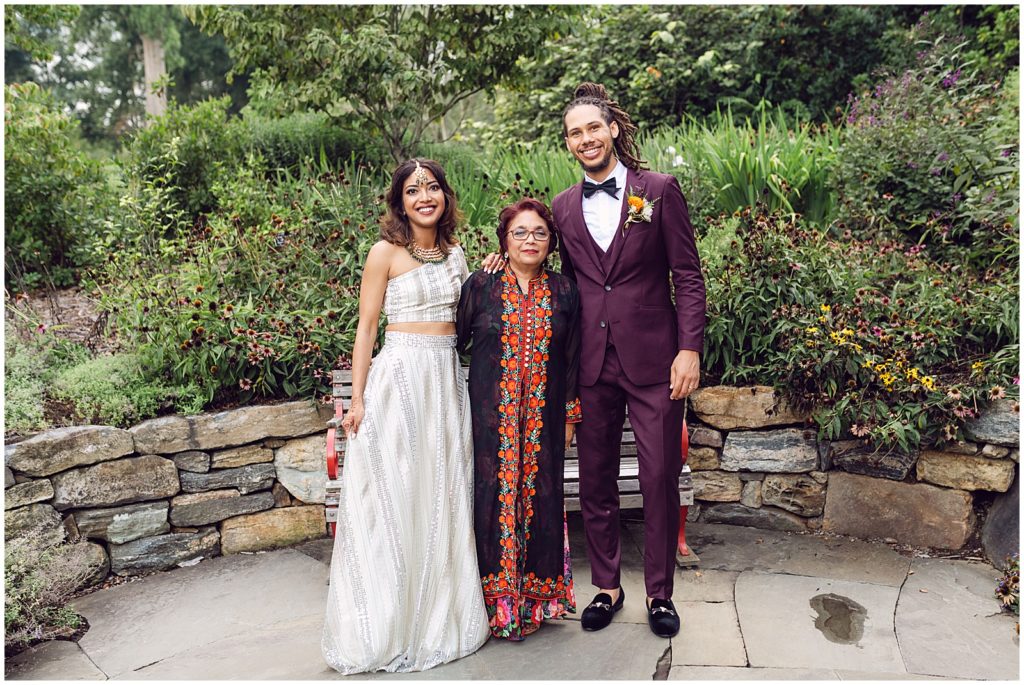 The couple poses with a family member in traditional Indian clothing.