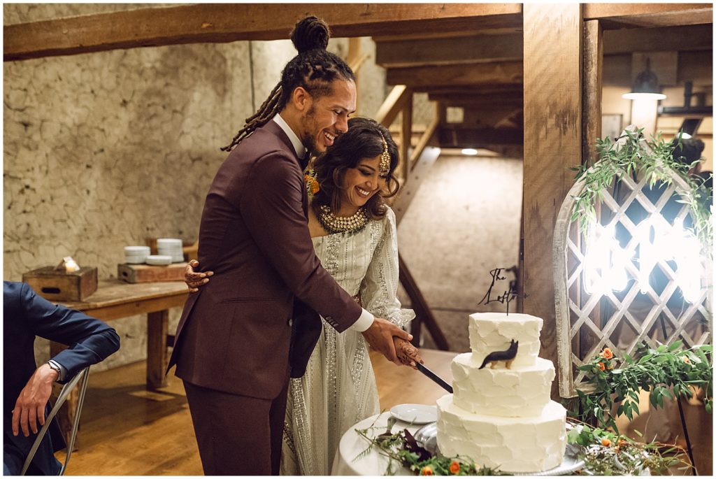The Tyler Arboretum wedding couple cuts their cake.