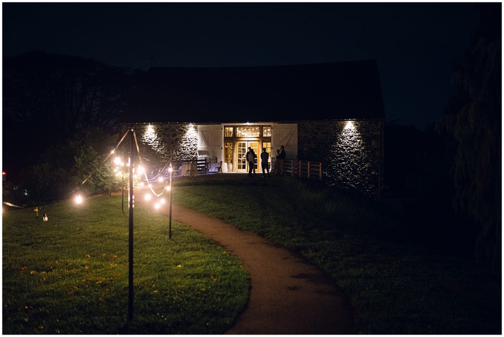 A lodge is lit up at night for the wedding reception.