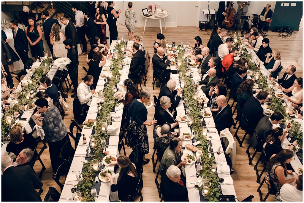 Guests sit at two long tables to eat dinner.