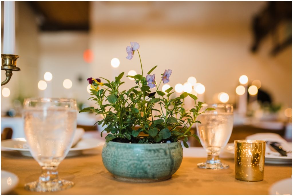 Sustainable wedding decor includes a handmade planter with purple flowers.
