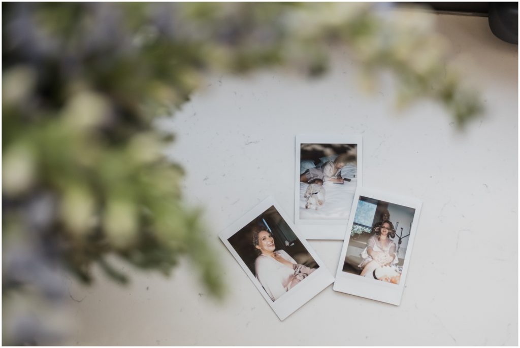 Wedding Polaroids sit on a table in the getting ready suite.