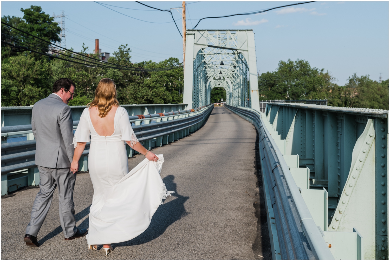 Tori and Alex walk along the Pencoyd Bridge outside their Manayunk wedding venue.