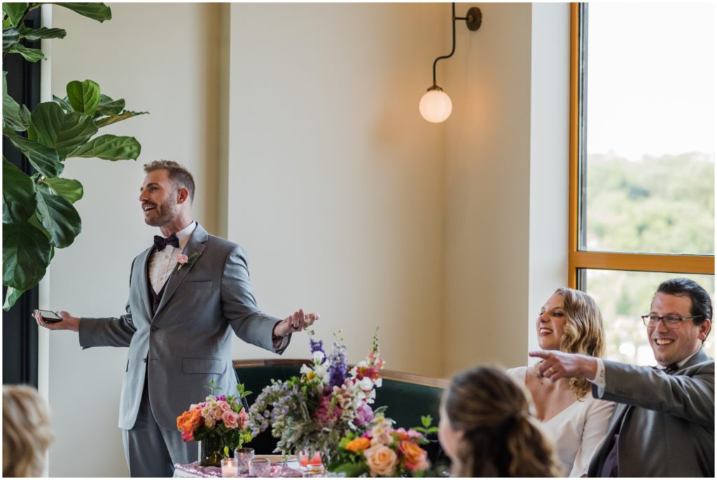 A groom laughs and points to guests at a Manayunk wedding venue.