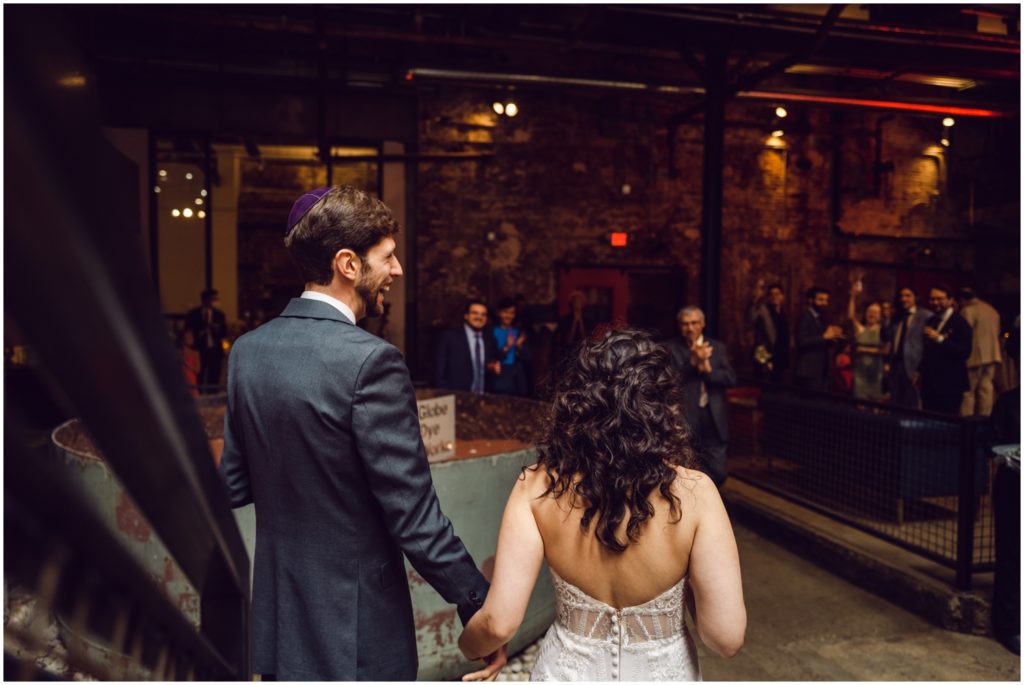 The couple enters their wedding reception by coming down a staircase.