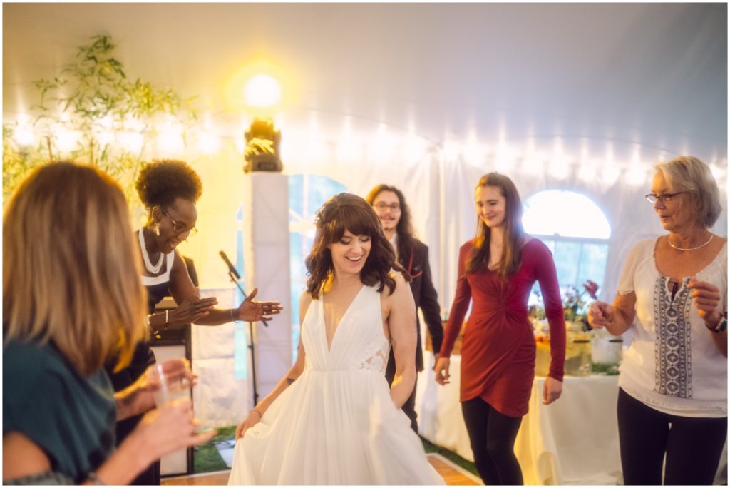 The bride dances in a circle surrounded by friends.