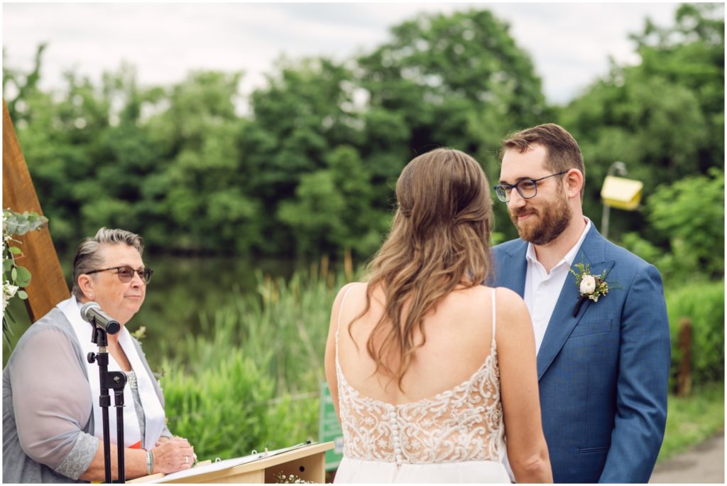 The officiant reads while the couple smiles at each other.