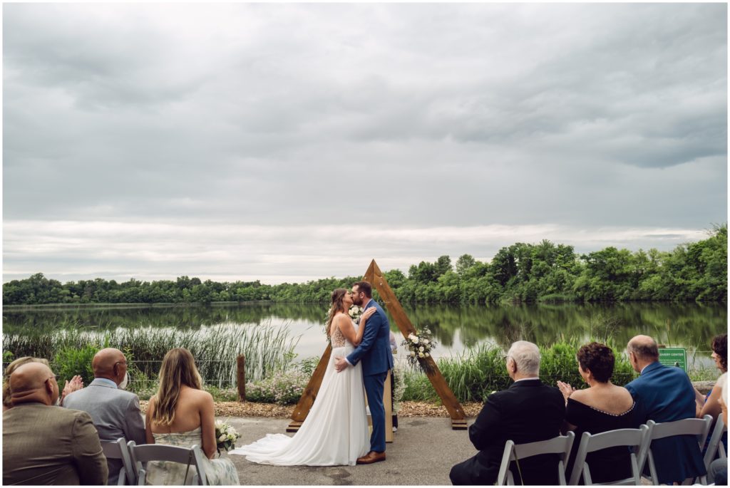 The first kiss ends the ceremony beside the reservoir.