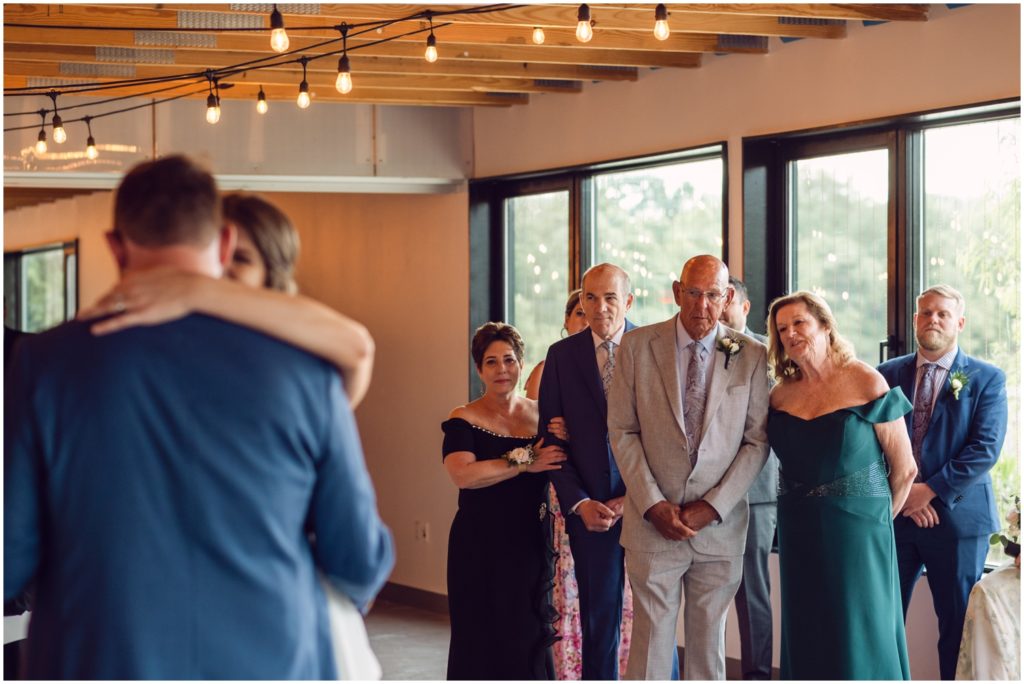 Family members watch the first dance from the side of the dance floor.