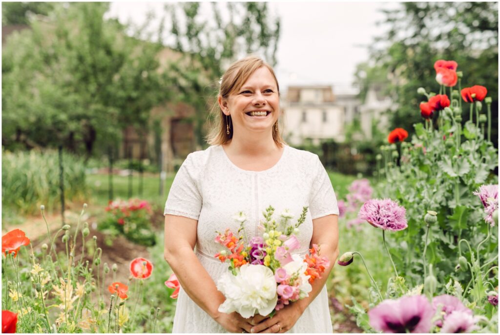 A bride poses in a garden before her Wyck House wedding.