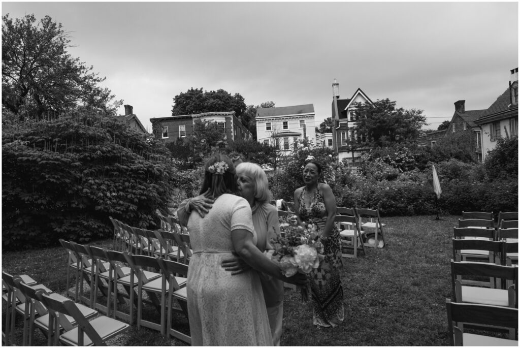Wedding guests embrace before a Philadelphia wedding ceremony.