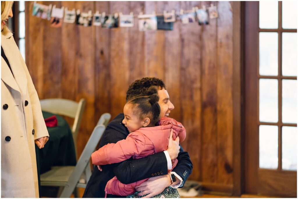 A groom embraces a child in a Philadelphia wedding venue.