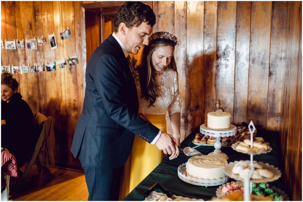 A bride and groom cut a wedding cake.