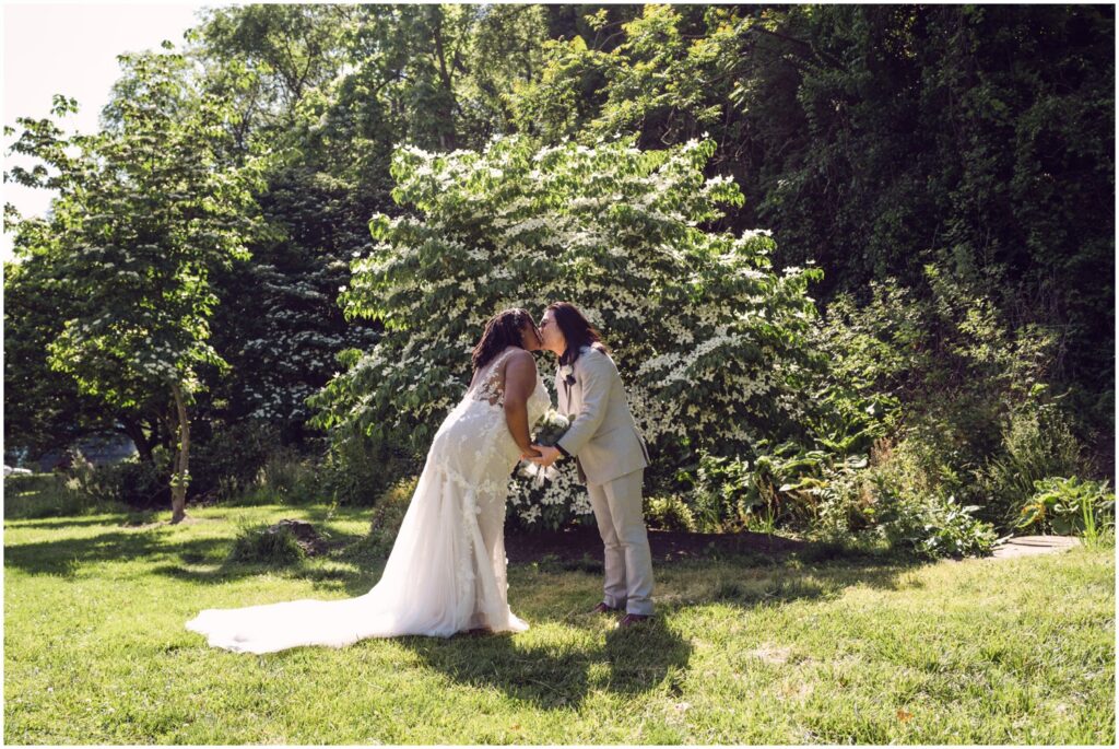 A bride and groom lean towards each other to kiss in a Philadelphia park.