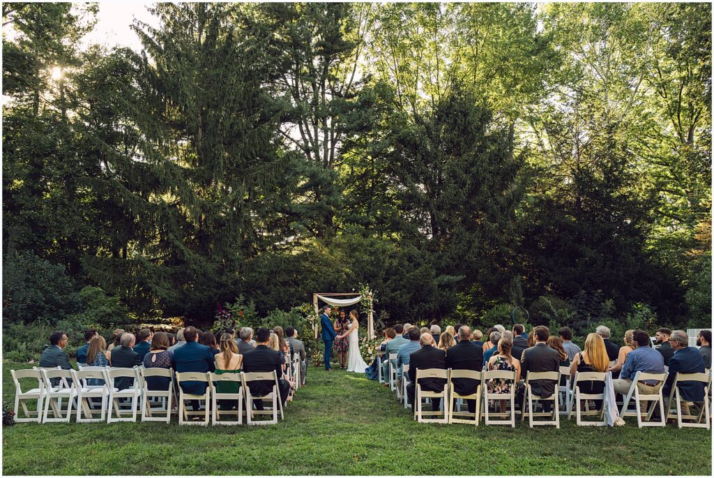 Wedding guests watch an outdoor wedding ceremony at a Philadelphia wedding venue.