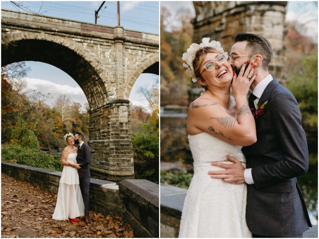 A groom kisses a bride's cheek beside the river in East Falls.