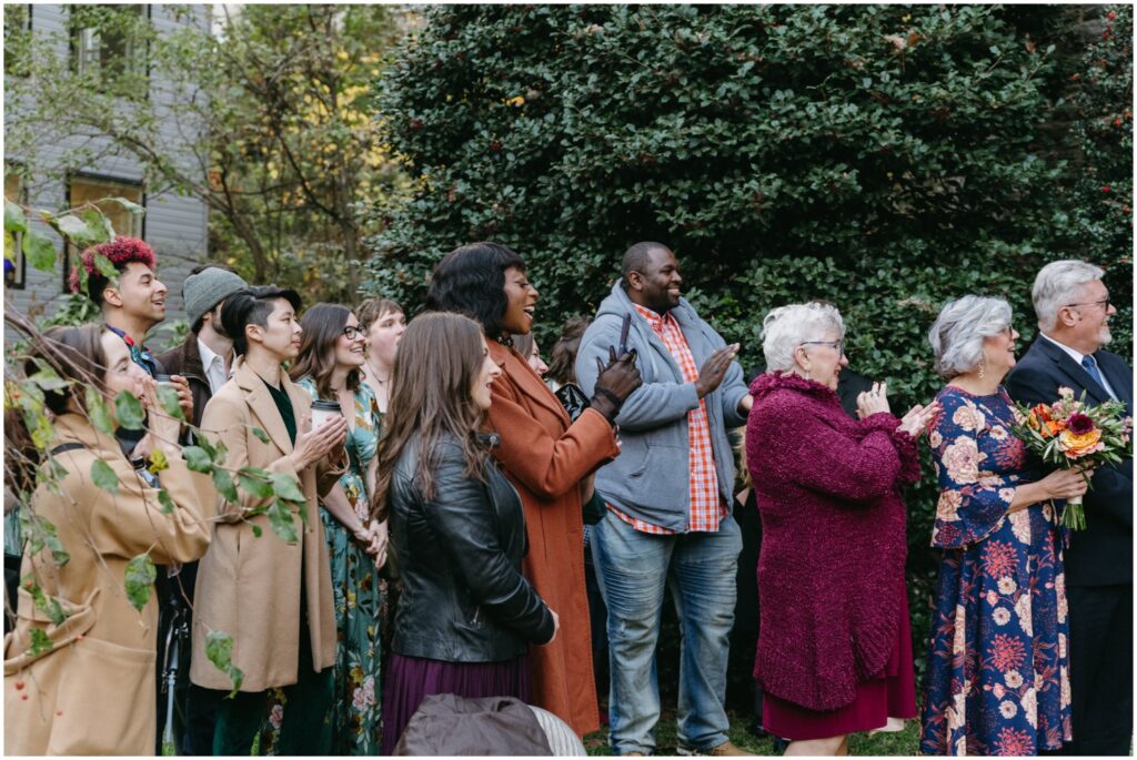 Wedding guests cheer for a bride and groom at an outdoor wedding in Philadelphia.