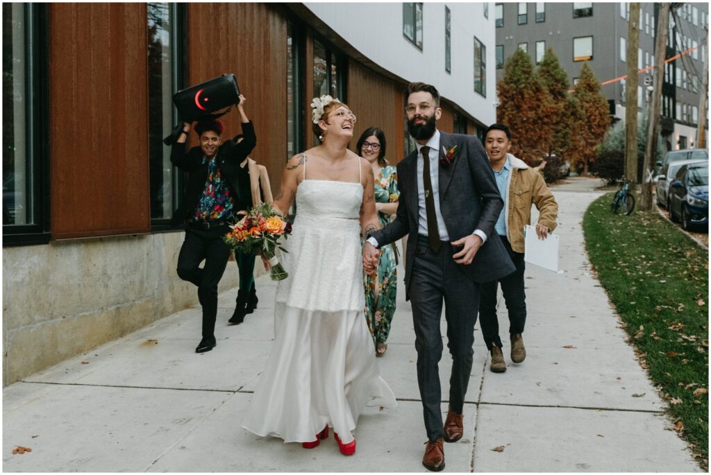 A bride and groom lead a wedding parade to their Philadelphia wedding reception venue.