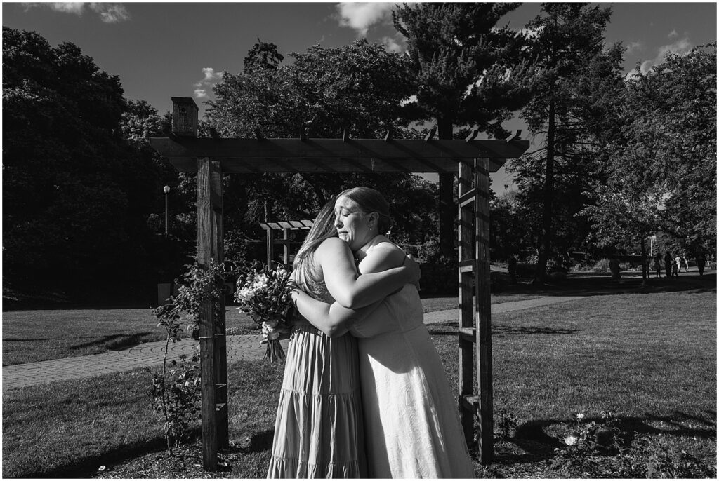 A bride hugs a family member.