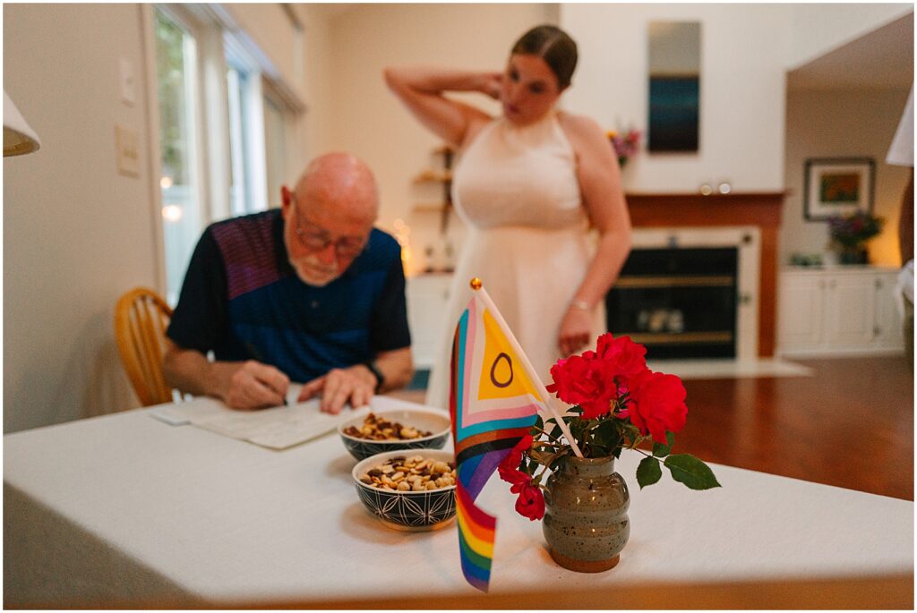 A bride's father signs her marriage license as a witness.