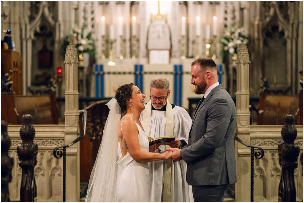 A bride and groom stand at a church altar during their wedding ceremony.