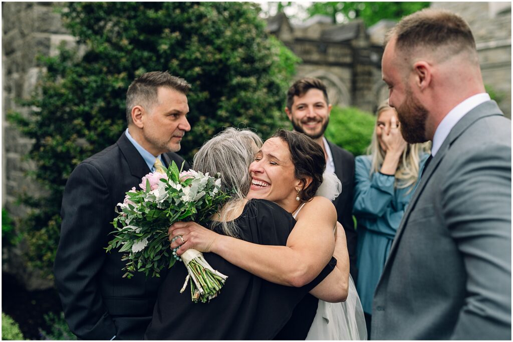 A bride hugs a family member outside her Philadelphia wedding venue.