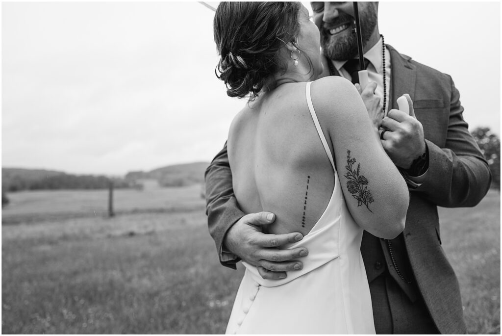 A bride and groom dance in a field.