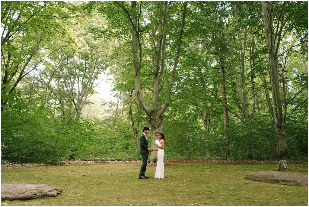 A bride reads her vows beneath some trees at Bowman's Hill Wildflower Preserve.