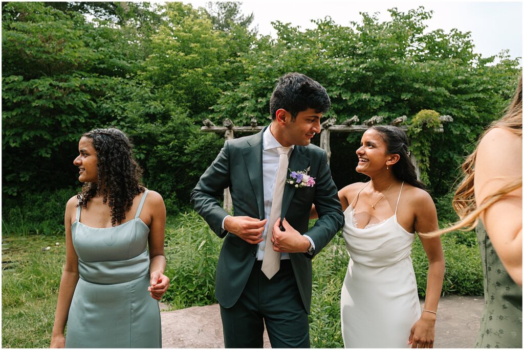 A bride and groom smile at each other after their garden wedding.