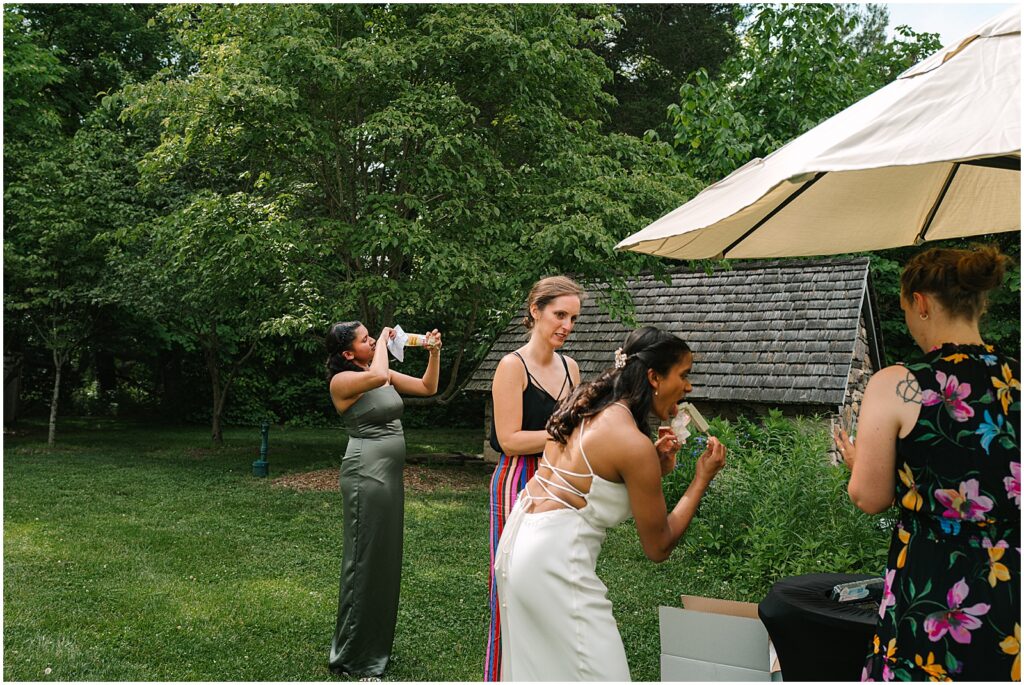 A bride eats a popsicle at a summer wedding reception.