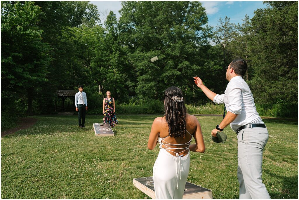 A bride plays lawn games at a summer wedding.