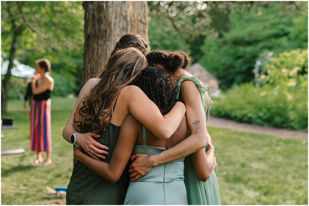 A group of bridesmaids hug each other.