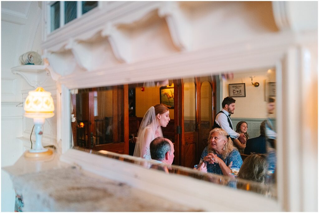 A bride stands beside a table of wedding guests at her Philadelphia micro wedding.