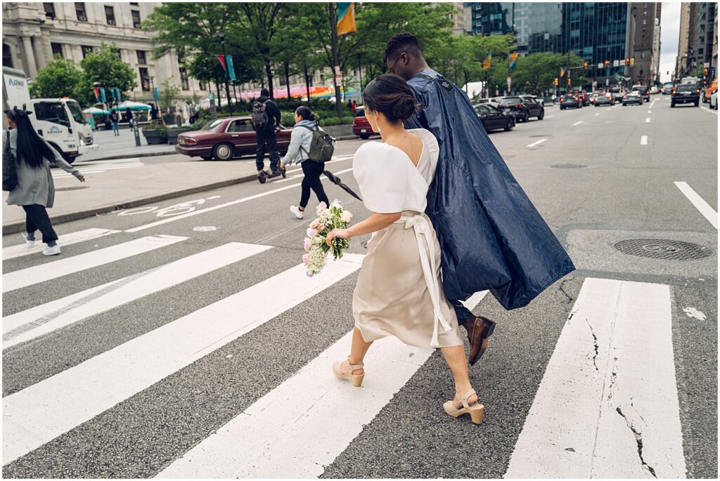 A bride and groom cross a Philadelphia street.