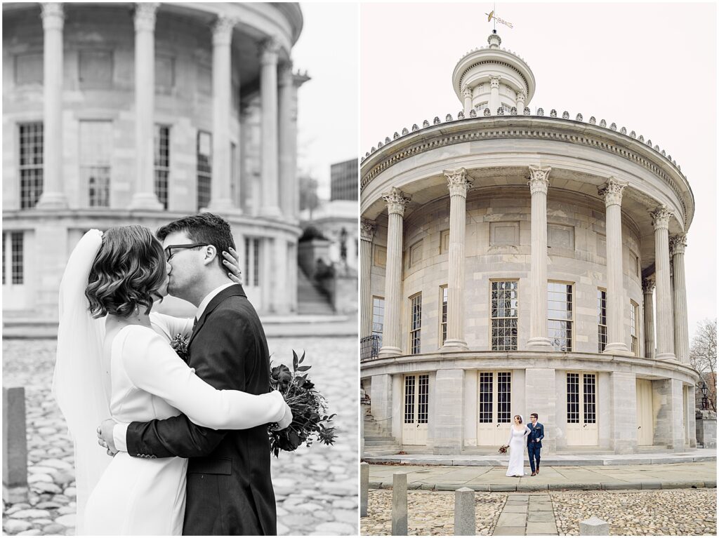 A bride and groom kiss in front of a historic building in Philadelphia.